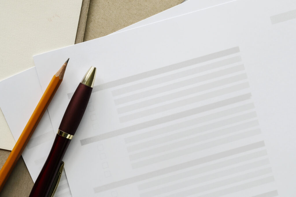 Crayons et documents sur table beige.